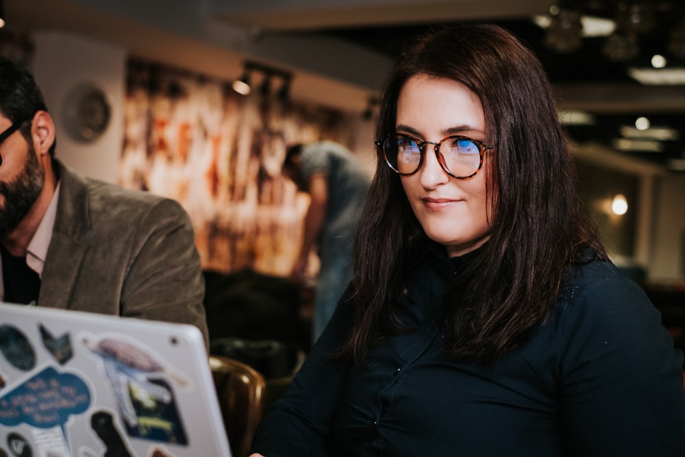 Mujer con chaqueta negra con gafas montadas negras