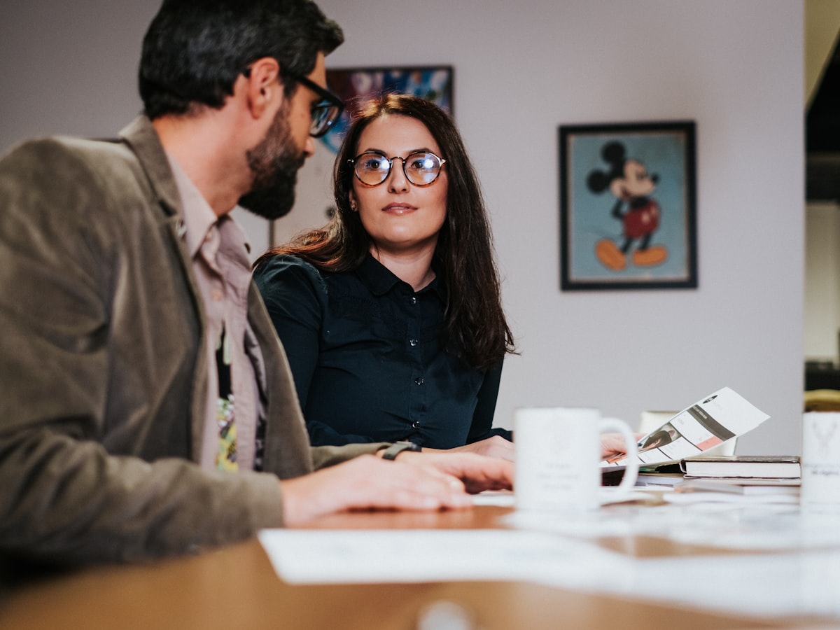 Man and woman sitting at a table working together in a small business office setting