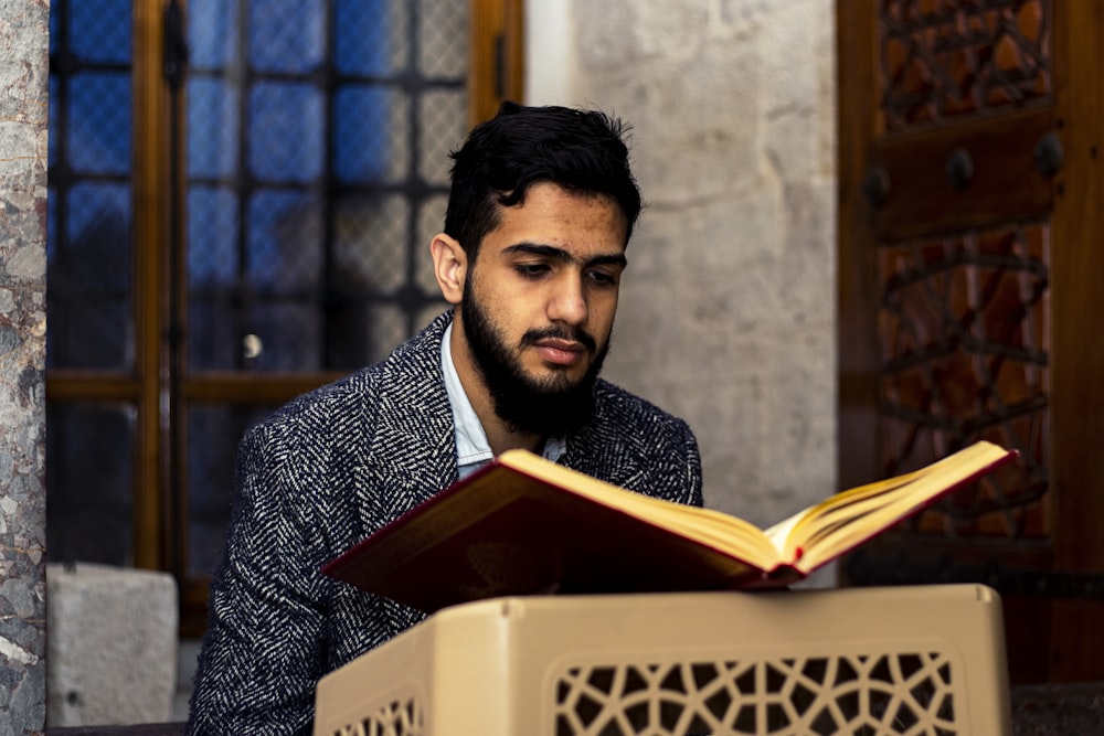 man in black and white suit reading book