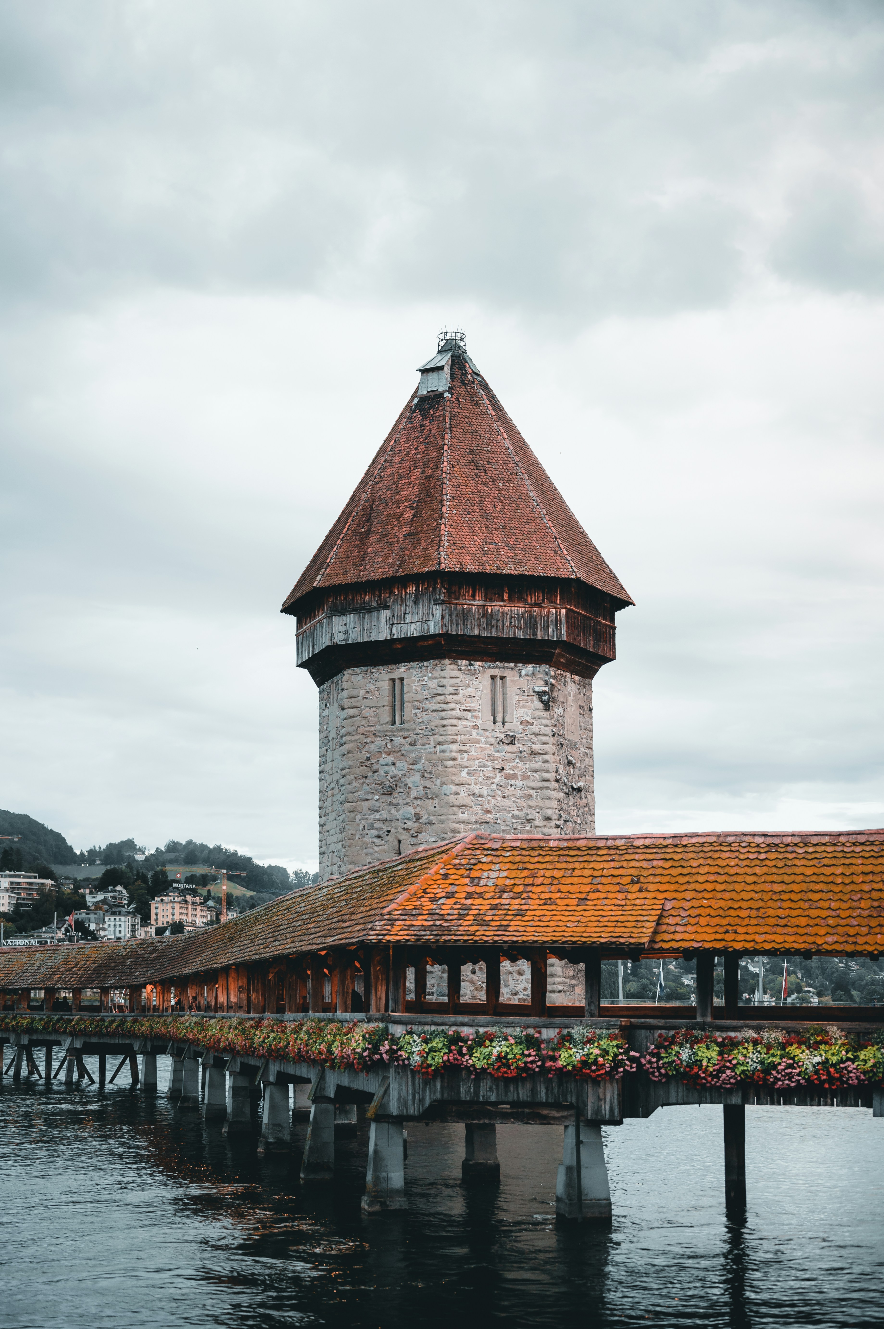 brown brick building near bridge under cloudy sky during daytime