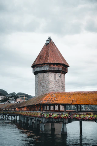 brown brick building near bridge under cloudy sky during daytime