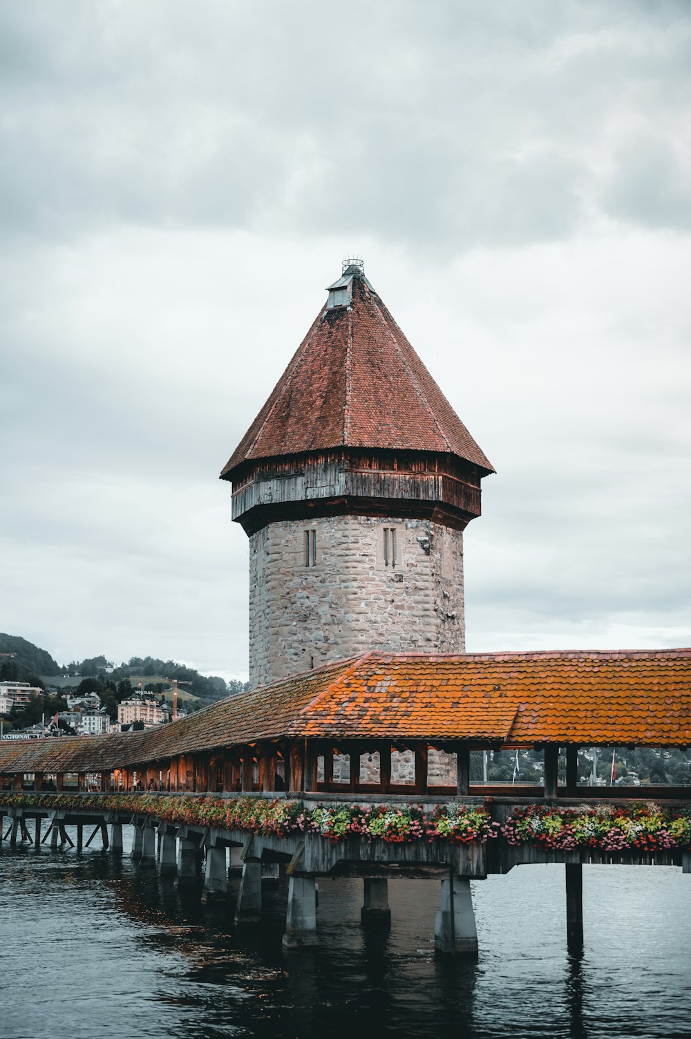 brown brick building near bridge under cloudy sky during daytime