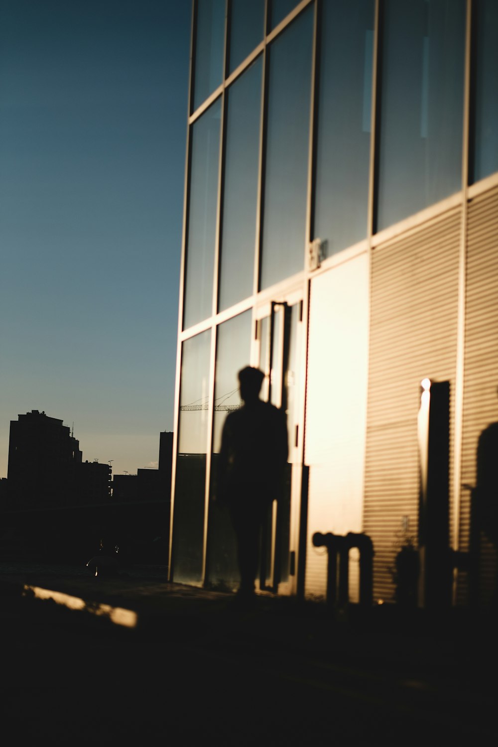 silhouette of man standing in front of building during night time