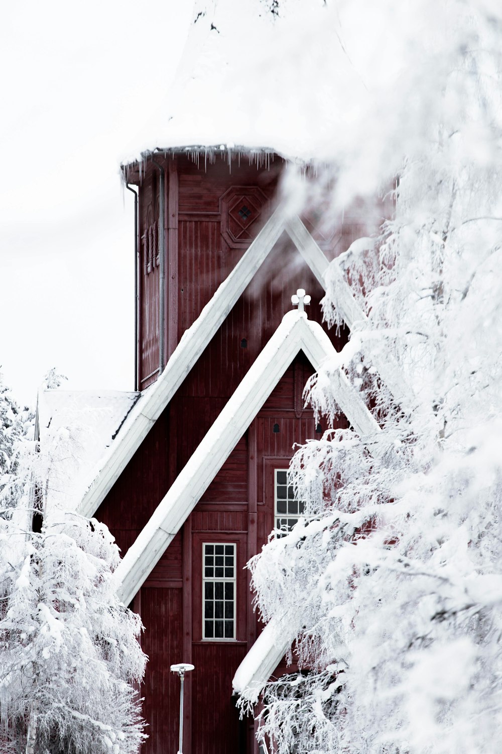 Casa de madera roja cubierta de nieve