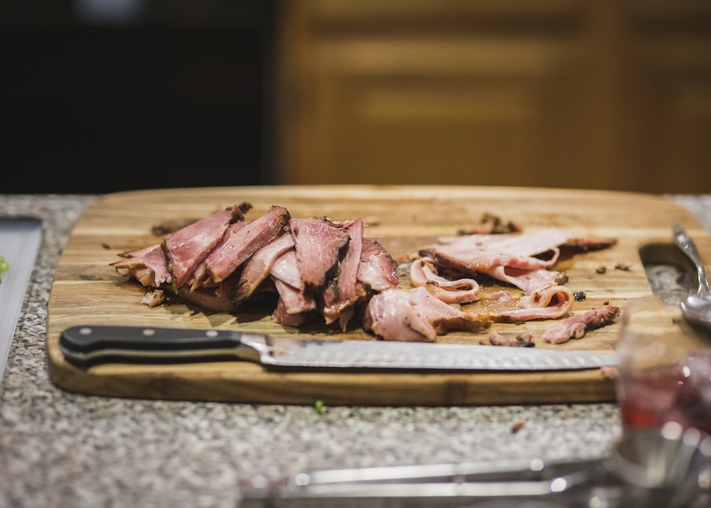 sliced raw meat on brown wooden tray