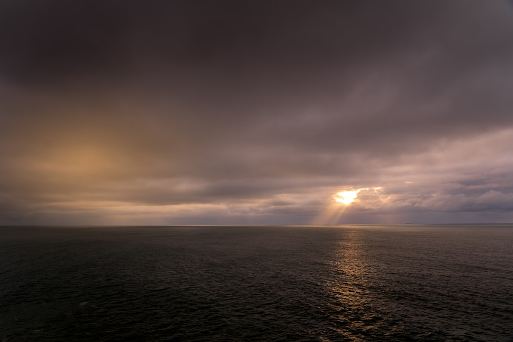 Plan d’eau sous ciel nuageux au coucher du soleil