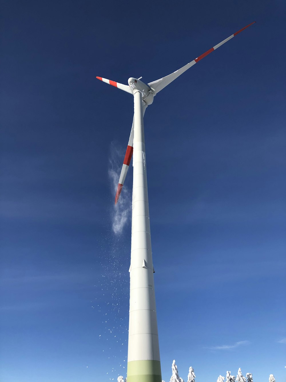 white wind turbine under blue sky during daytime