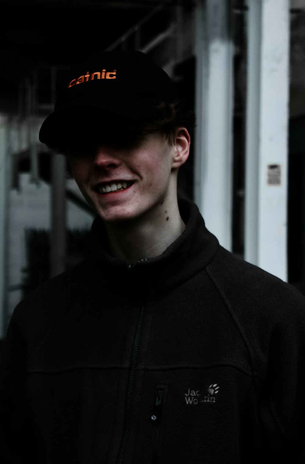 man in black zip up hoodie wearing black cap