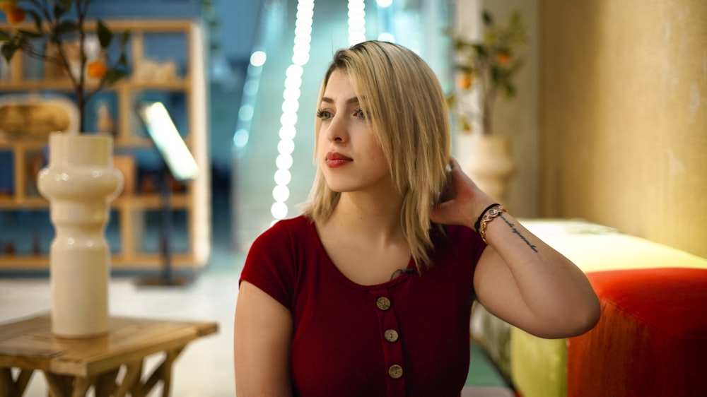 woman in red crew neck t-shirt sitting on chair