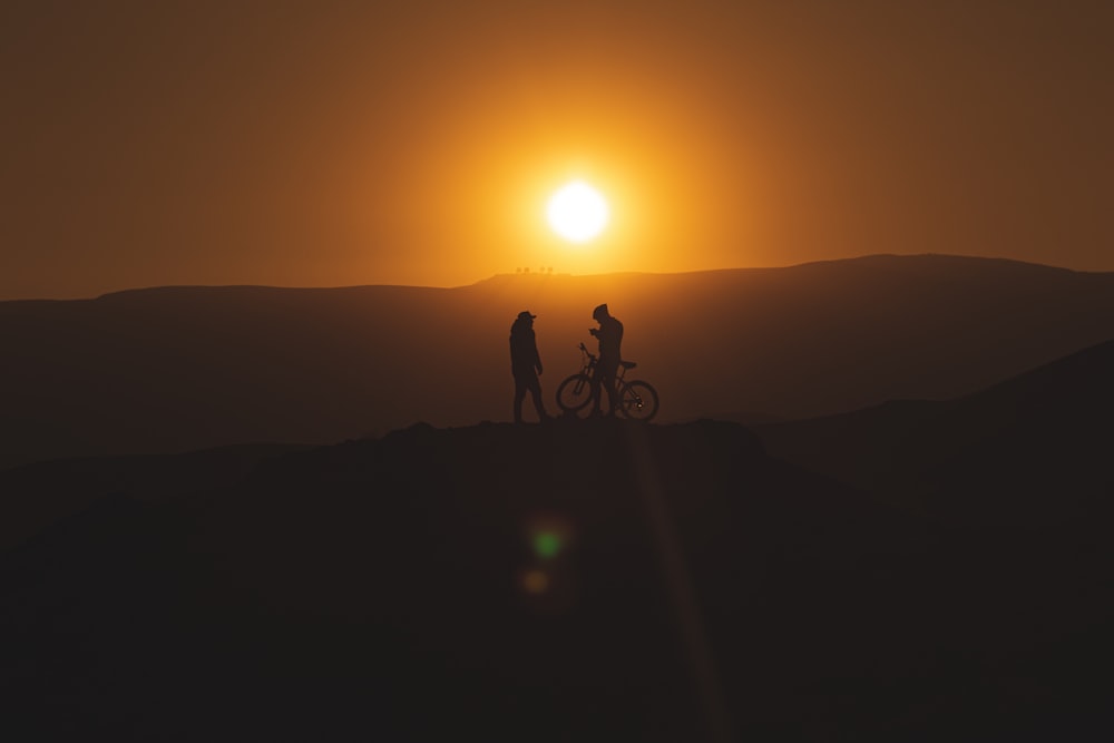 silhouette of man riding bicycle during sunset