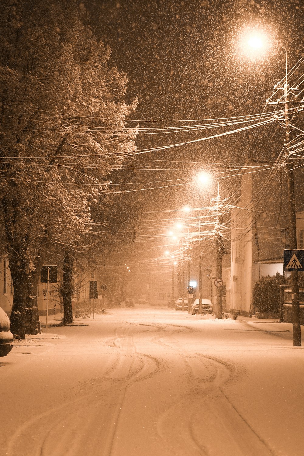 Eine verschneite Straße bei Nacht mit Straßenlaternen