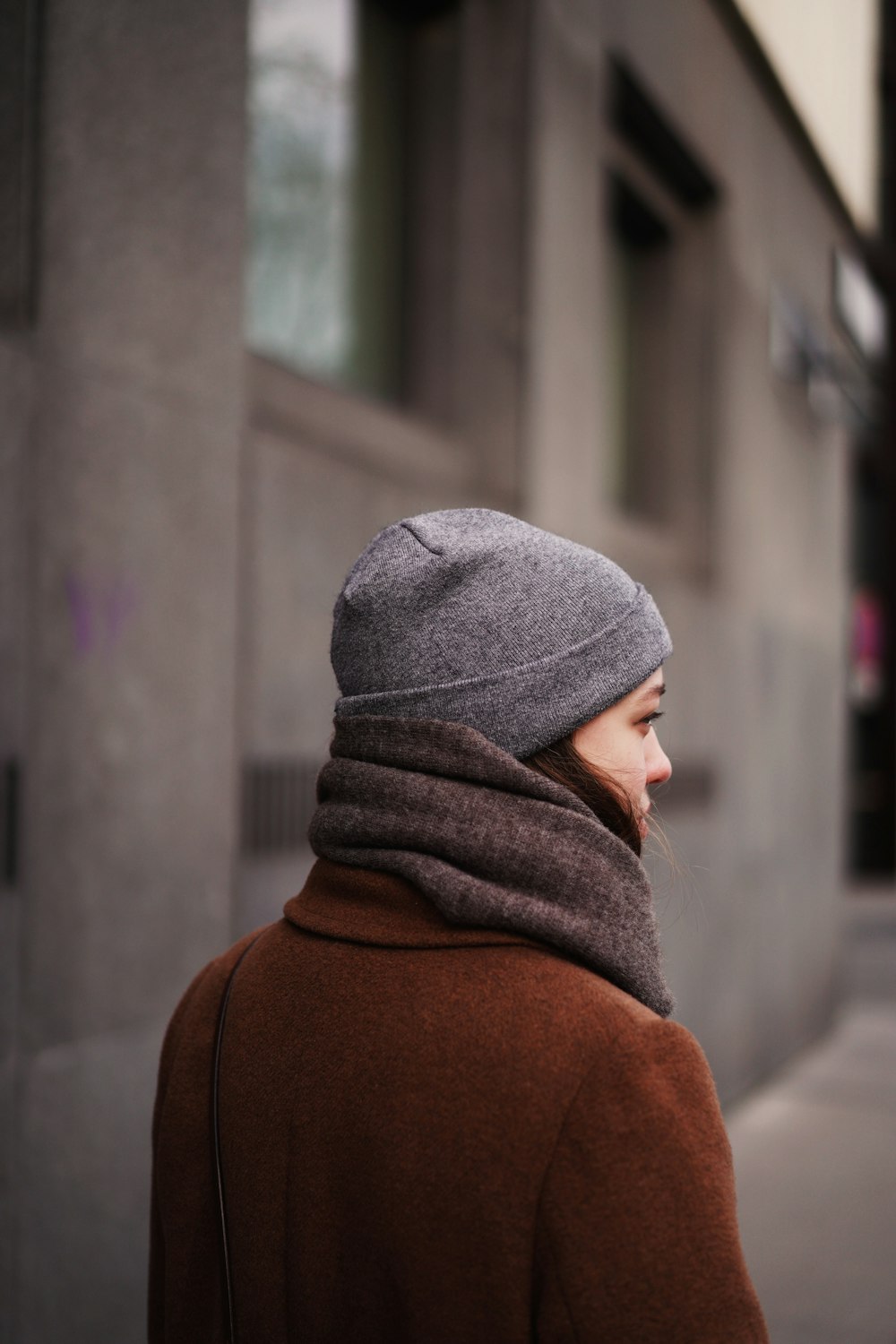 person in gray knit cap and brown hoodie