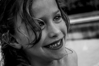 grayscale photo of smiling girl