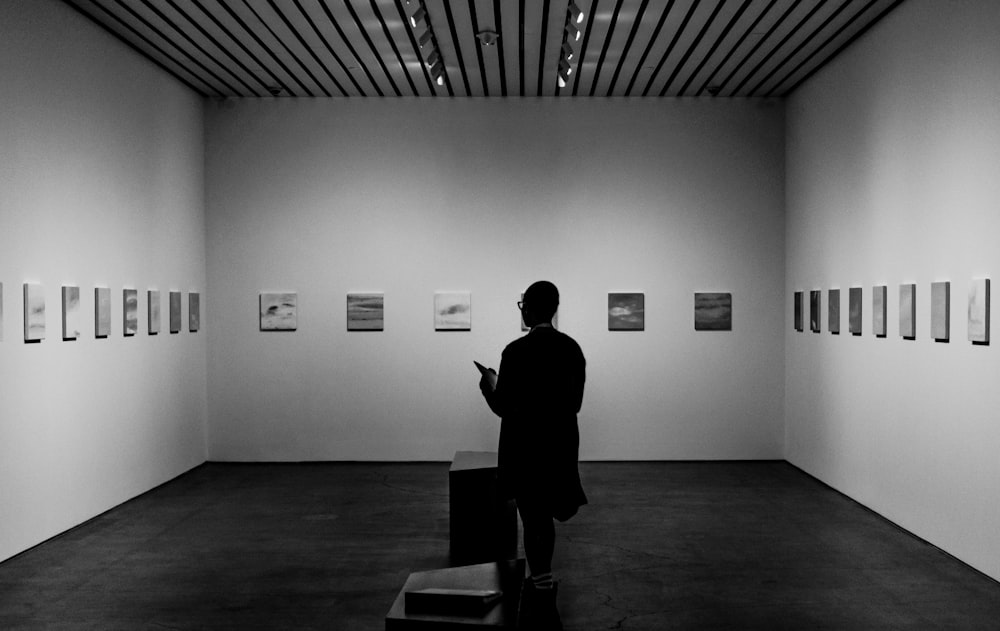 man in black shirt standing in front of white wall