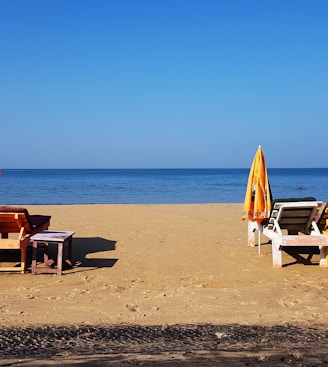 brown wooden chairs on beach during daytime