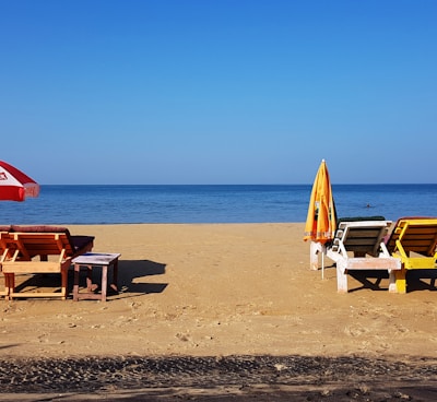 brown wooden chairs on beach during daytime