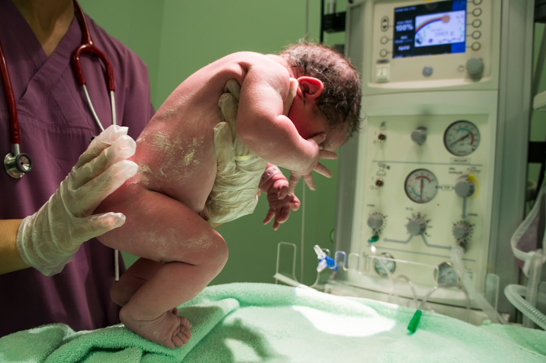 man in green scrub suit holding baby