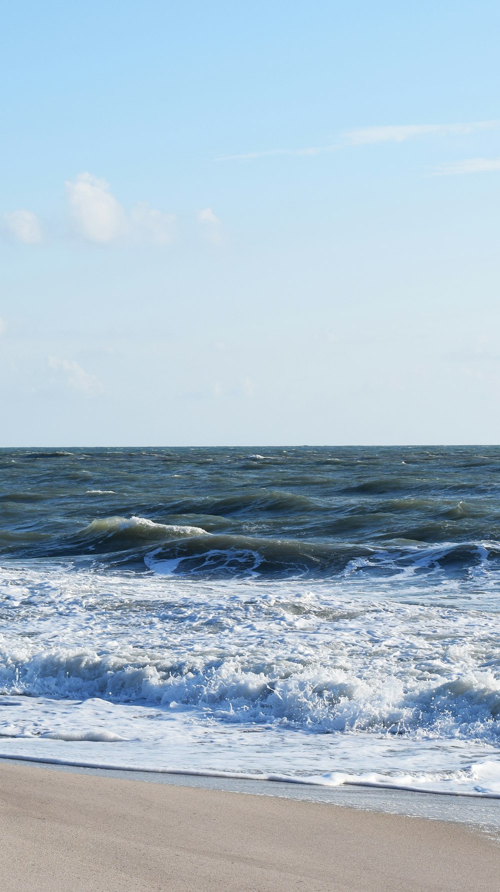 sea waves crashing on shore during daytime