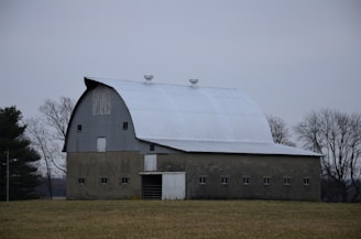 Large concrete barn structure with premolded panels in rural setting.