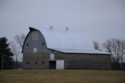 Large concrete barn structure with premolded panels in a rural setting.