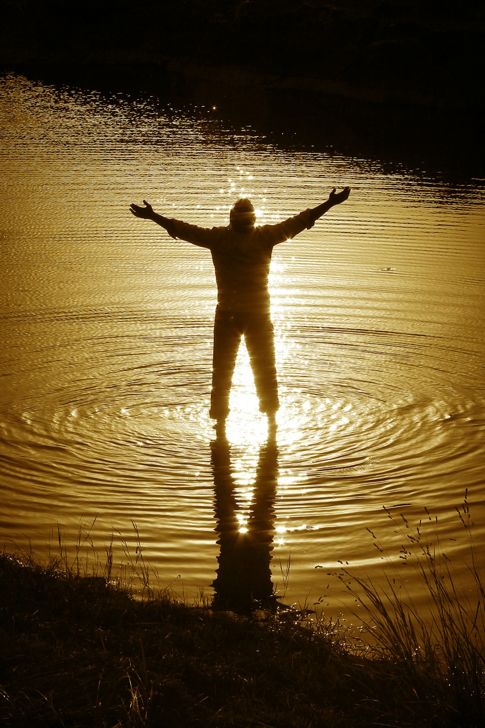 silhouette of person standing on water during daytime