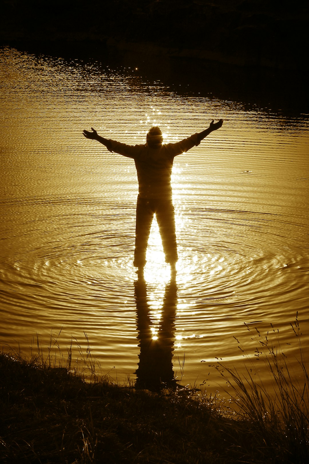 silhouette of person standing on water during daytime