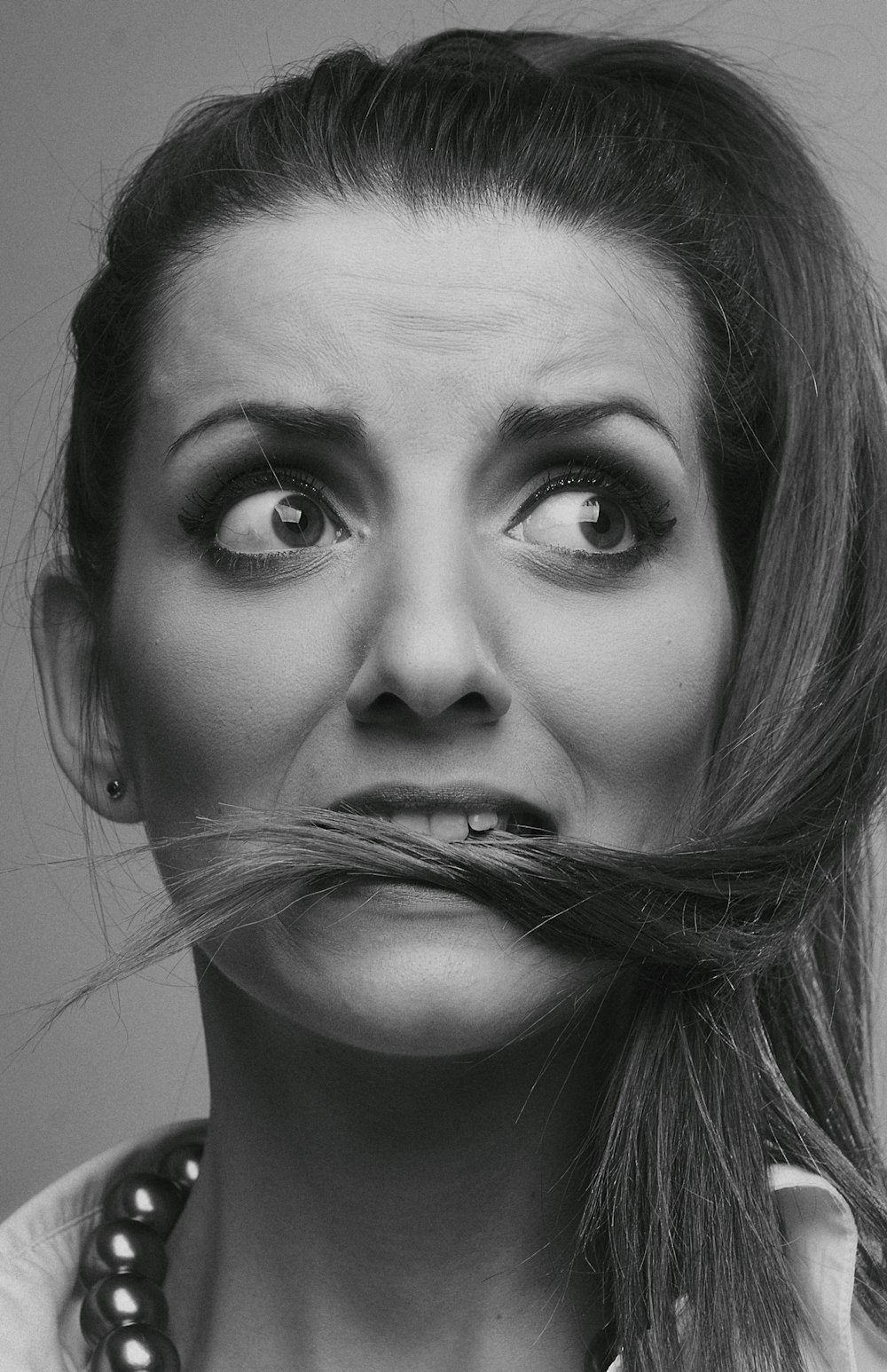 grayscale photo of woman with silver nose ring