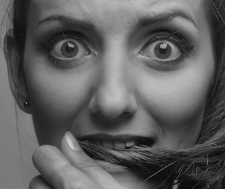 A close-up of eyes wide open in fear, set against a backdrop of swirling shadows and muted reds.