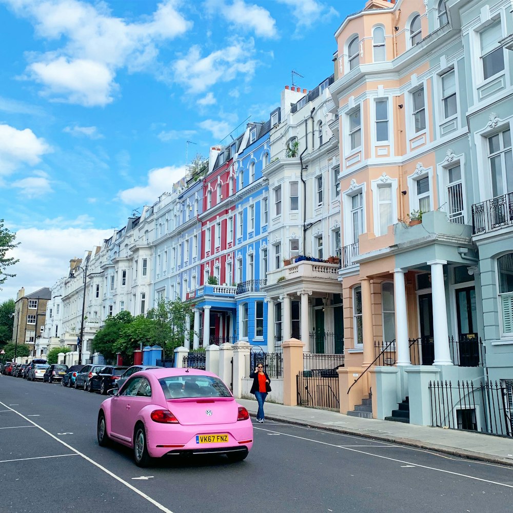 pink car on road near white concrete building during daytime