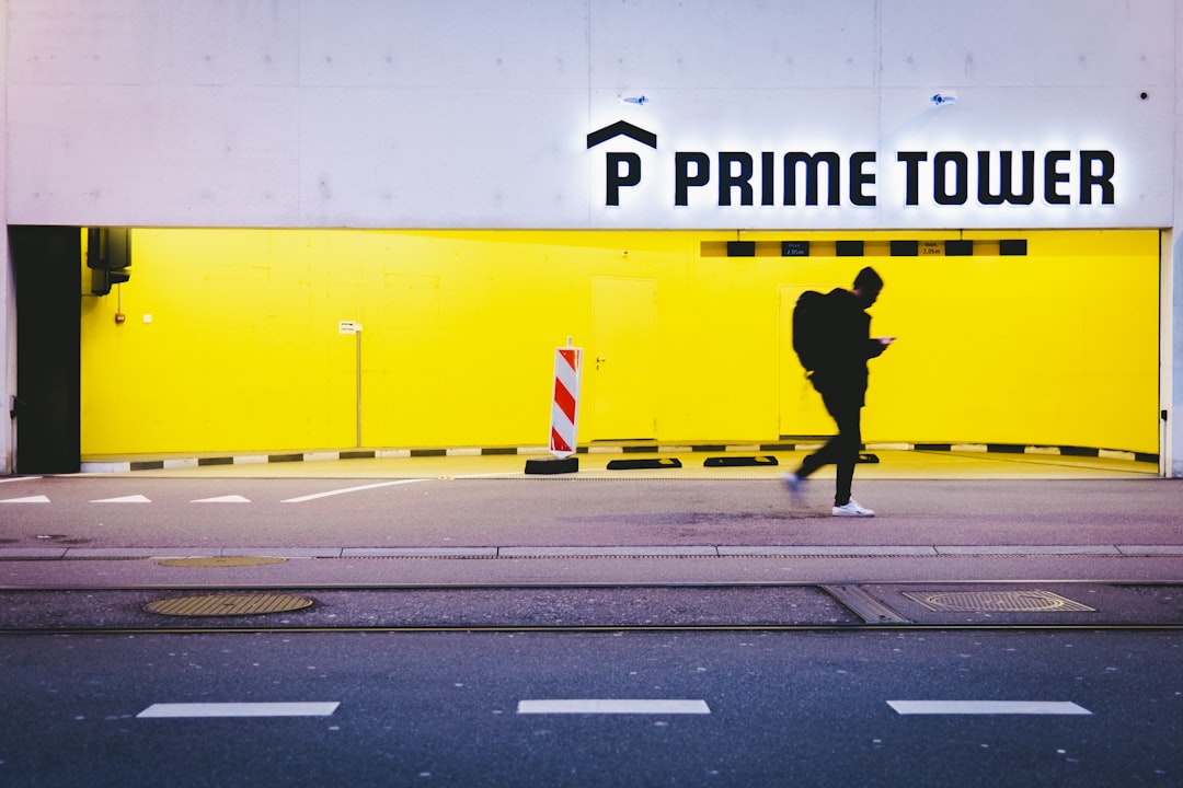 man in black jacket walking on pedestrian lane