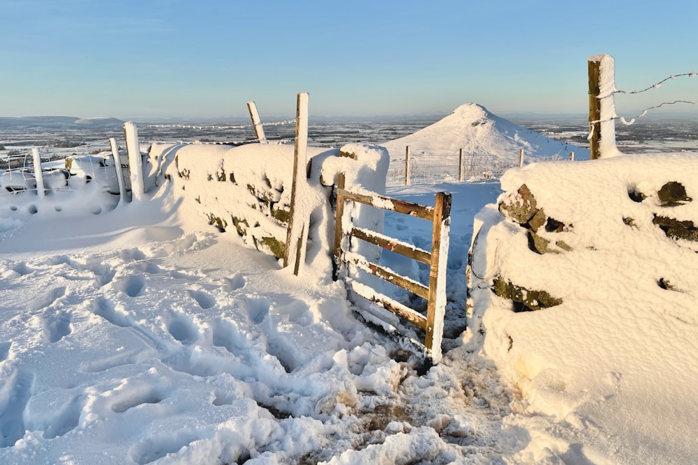 brown wooden fence on snow covered ground during daytime