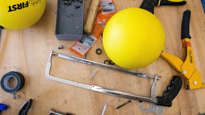 yellow ball beside gray metal tool