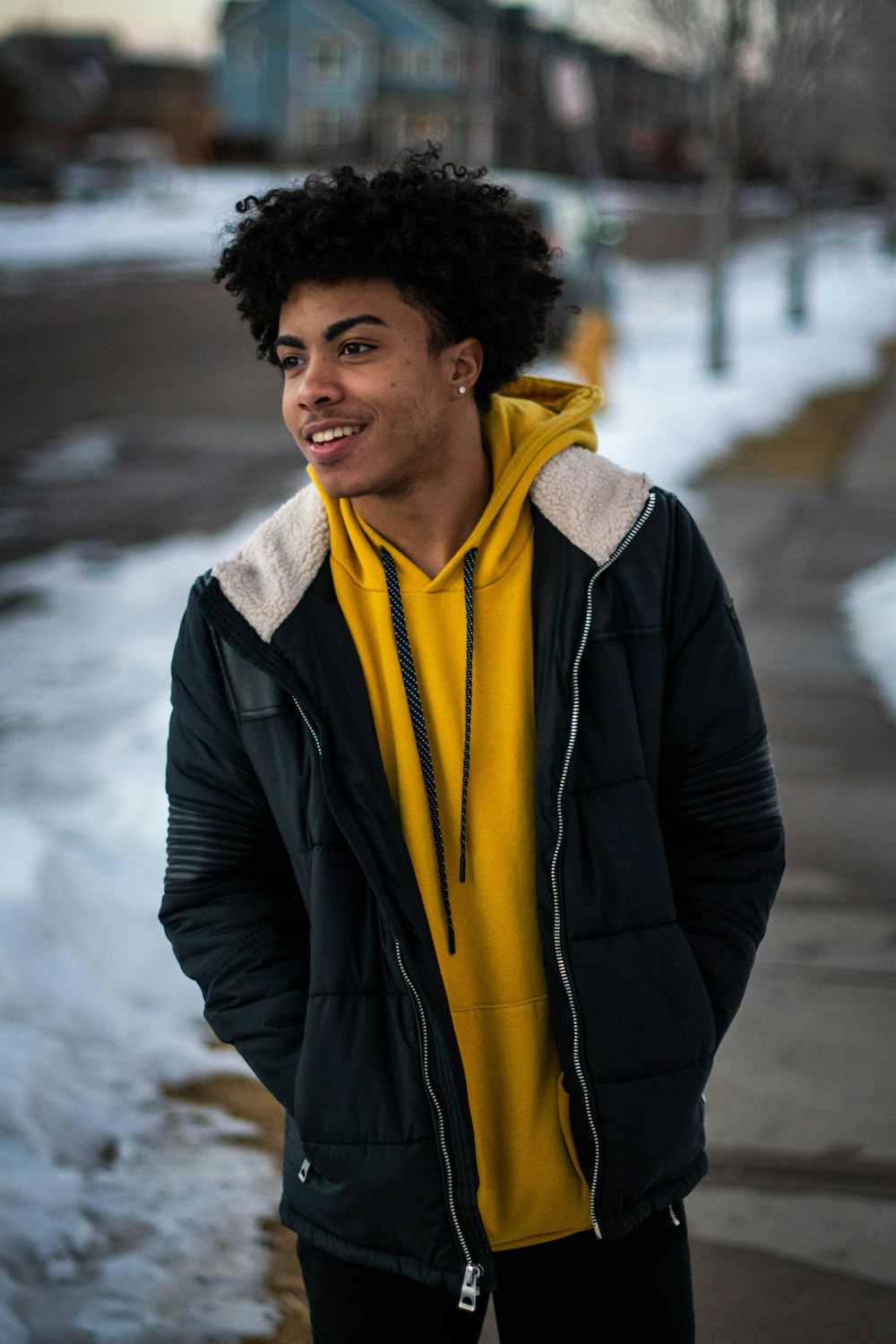 man in black jacket standing on snow covered ground during daytime