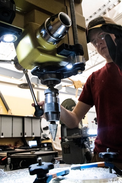 man in red crew neck t-shirt holding gray and black metal tool