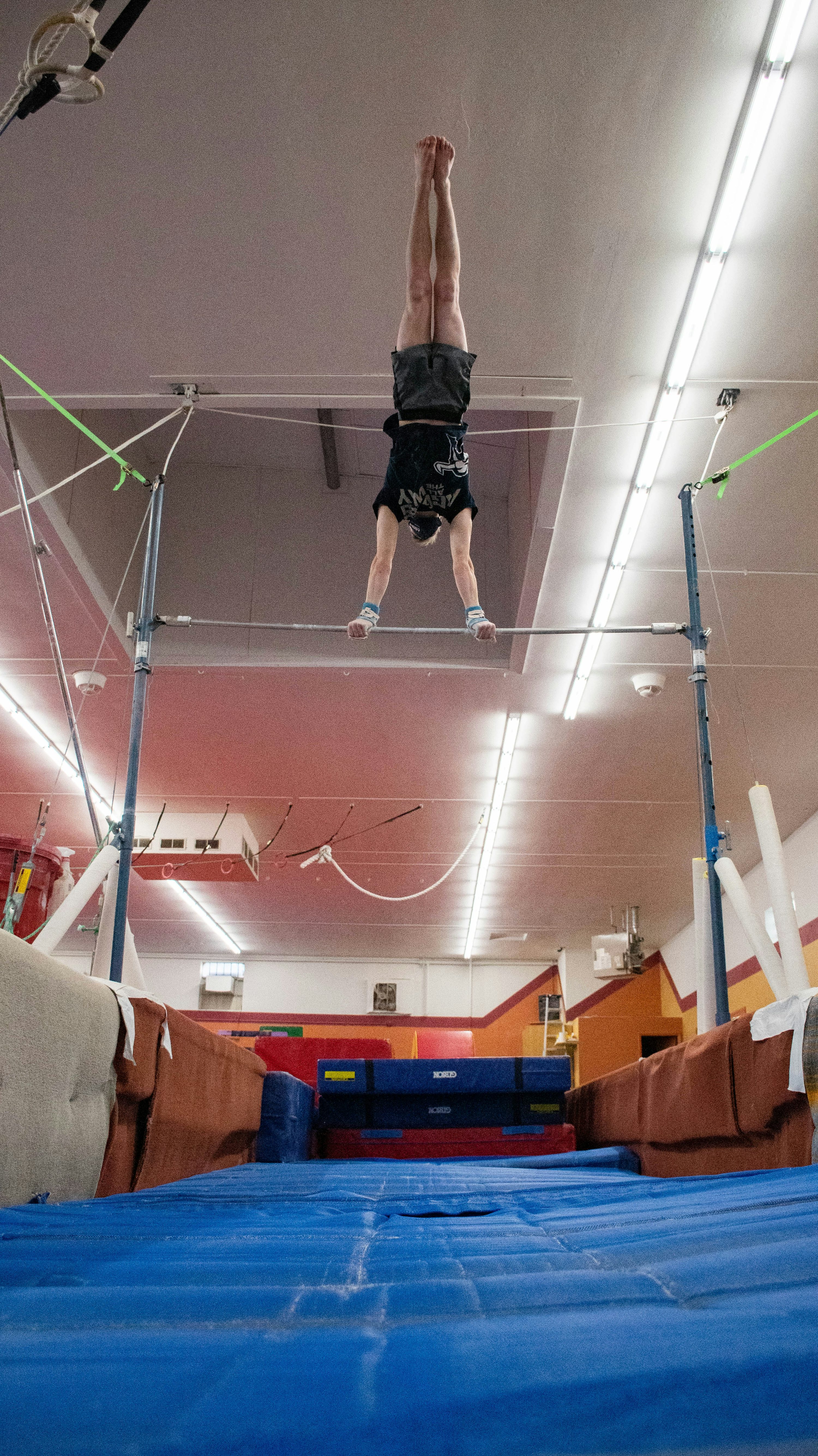 homme en chemise noire et short sautant sur un terrain de basket-ball