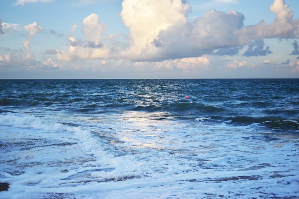 pessoa surfando nas ondas do mar durante o dia