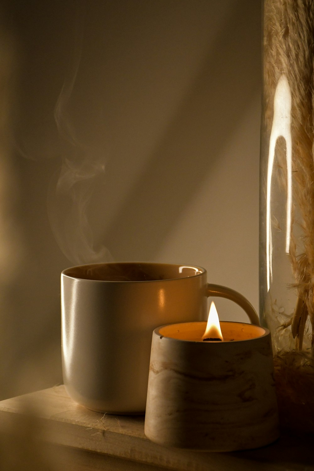 white ceramic mug with white candle