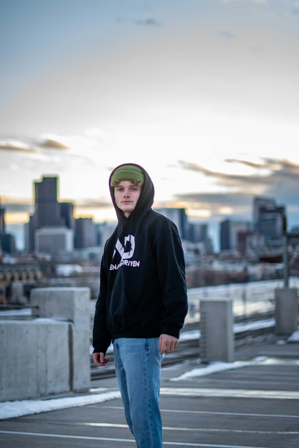 man in black hoodie standing on top of building during daytime