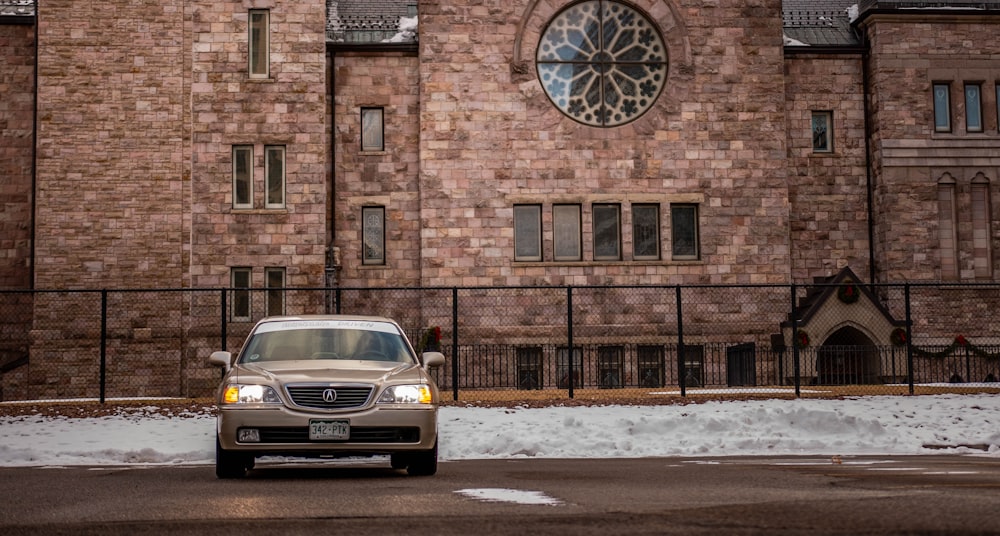 yellow car parked beside brown brick building during daytime