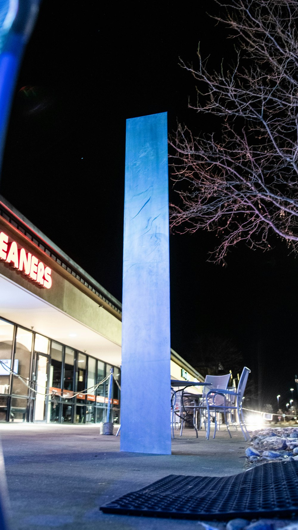 a tall blue pillar sitting in front of a building