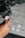 A close-up of a person inserting a 256 GB memory card into a digital camera. Several other memory cards are scattered on a gray surface nearby. The scene is focused on the camera and memory cards, highlighting their details.