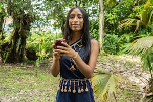woman in blue sleeveless dress holding brown wooden stick