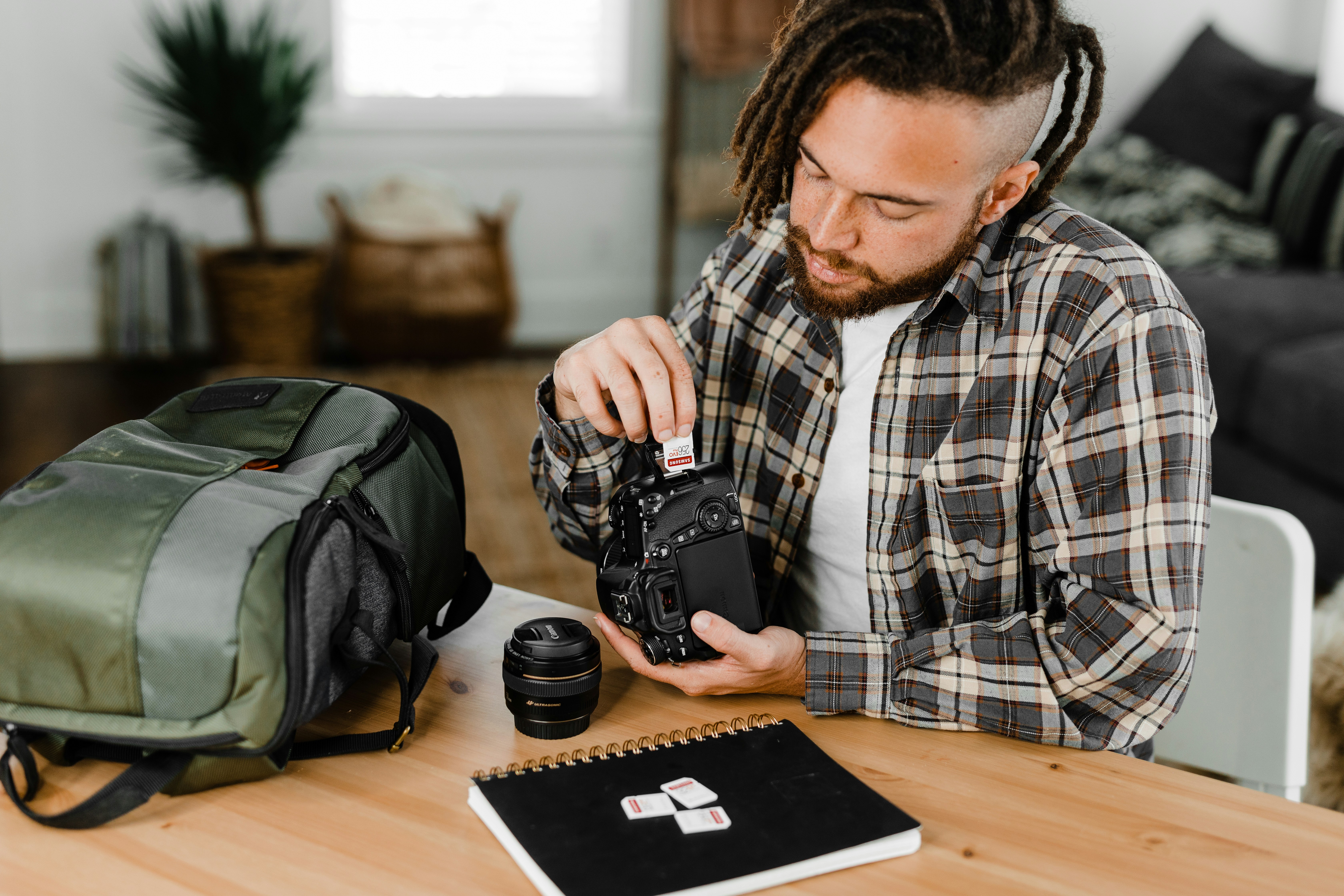man in black and white plaid dress shirt using black dslr camera