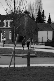 A candid black and white photograph capturing a quiet moment in a bustling city street.