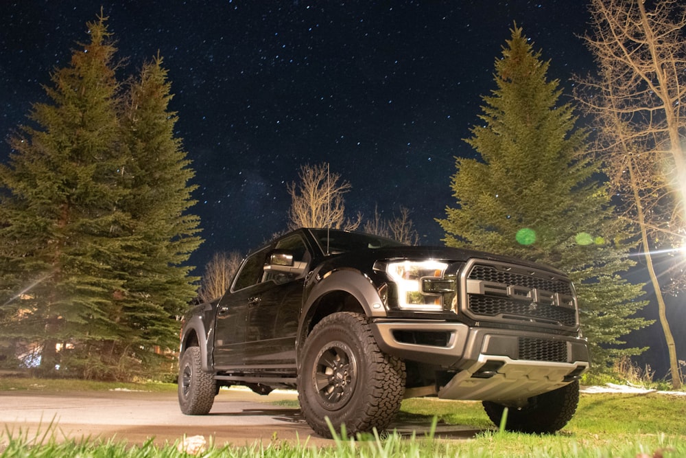 black suv on green grass field during night time