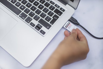 A hand plugging a Microdia USB into a laptop's USB port.