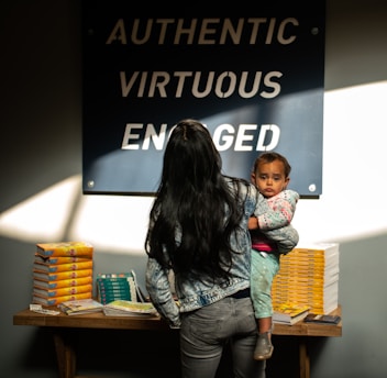 woman in blue denim jacket carrying baby in blue denim jacket