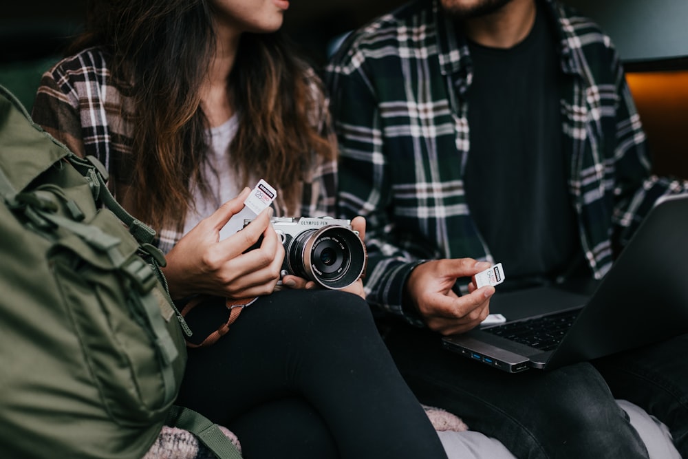 woman in green and white plaid shirt holding silver and black camera