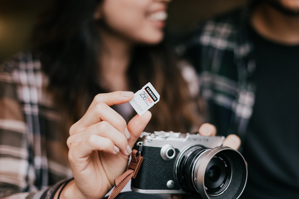 person holding silver and black camera