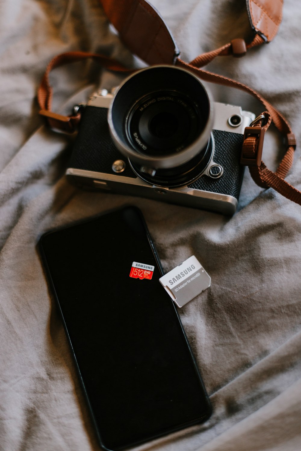 black and silver dslr camera on white textile